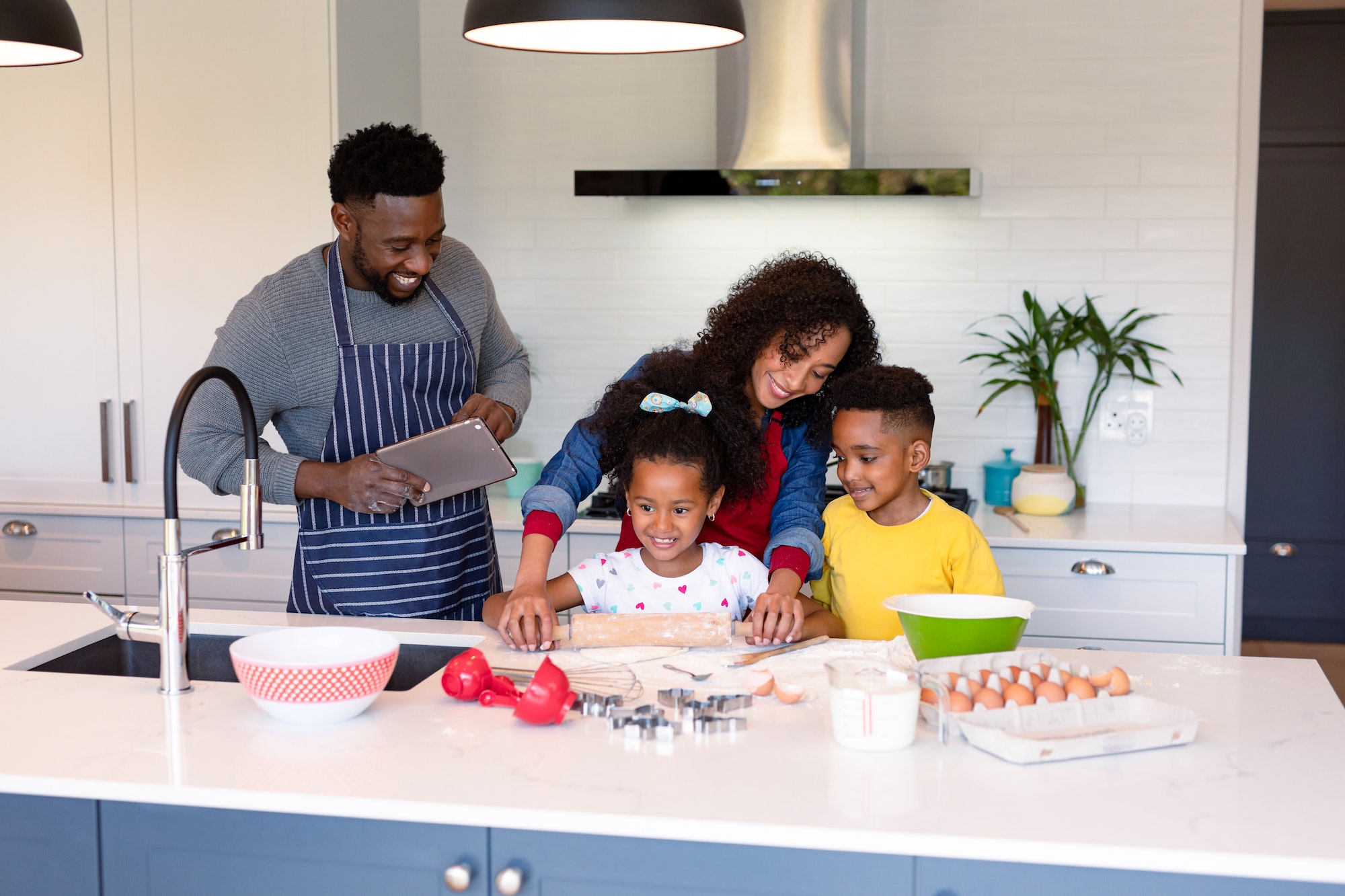 Happy african american family baking together in kitchen